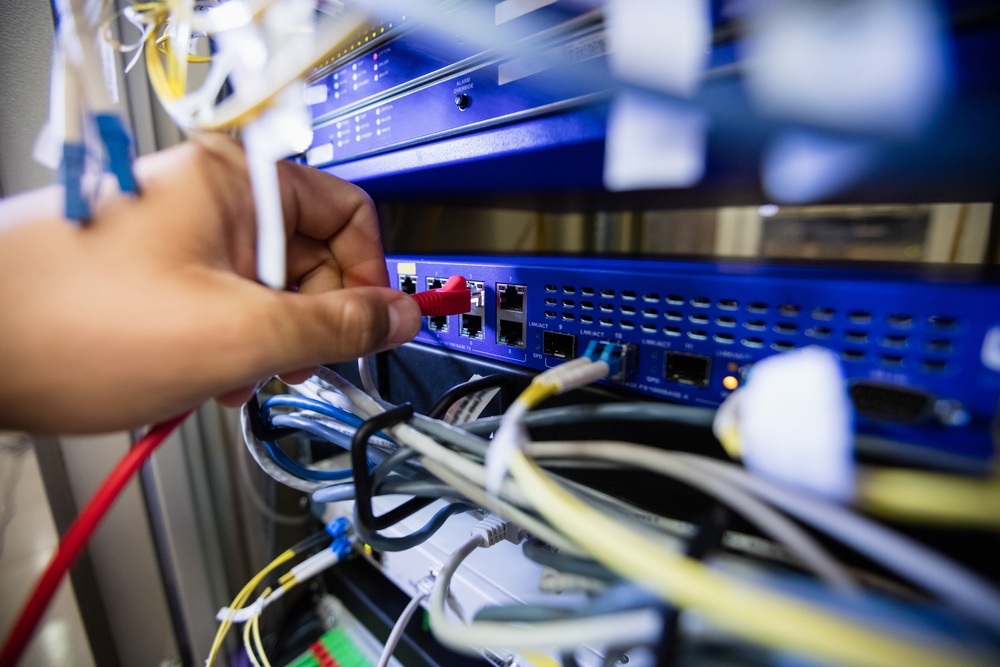 Close-Up of technician fixing patch cable in a rack mounted server